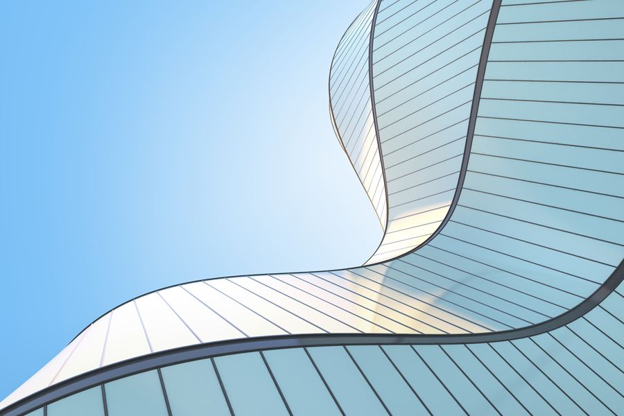 An abstract glass building wall from down below.