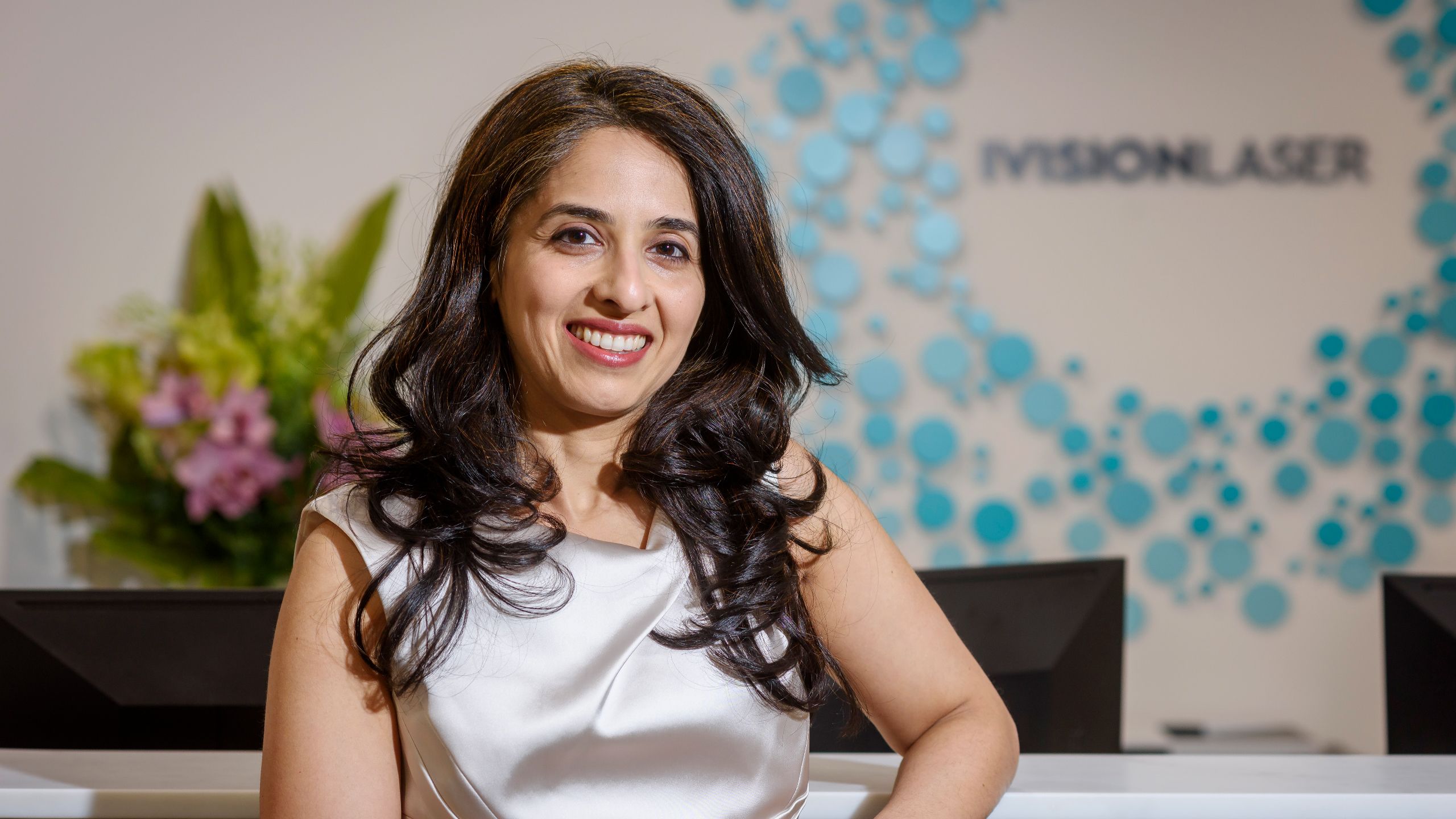 A profile shot of Dr Aanchal Gupta sitting and looking directly at the camera and smiling. 